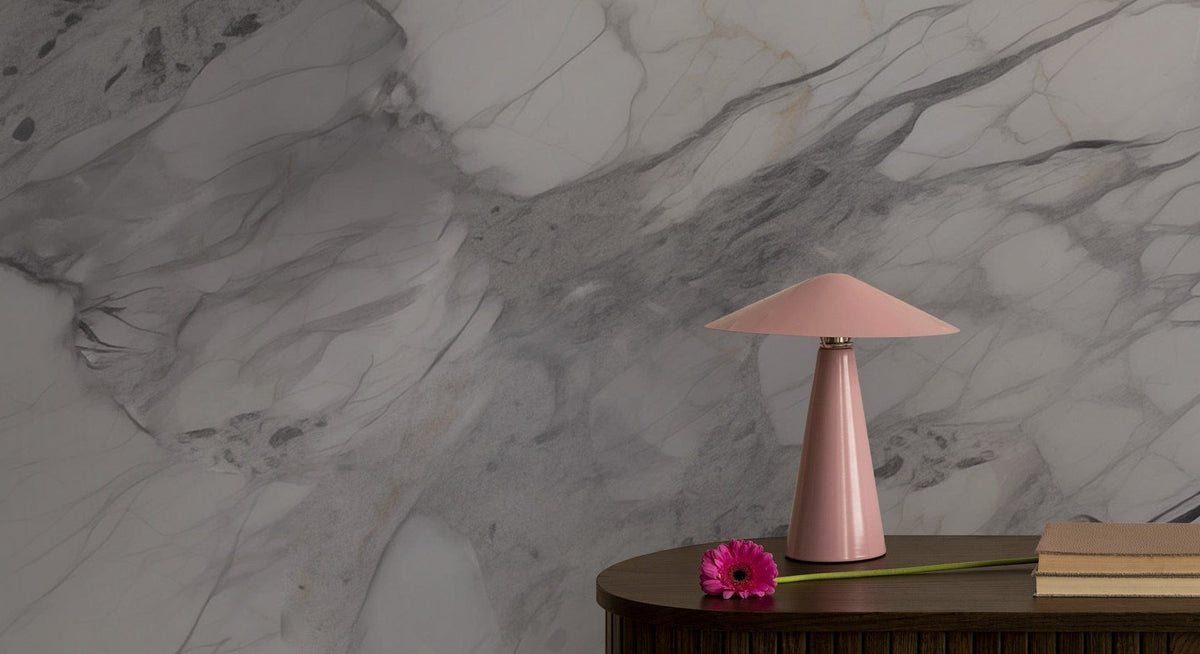 Elegant grey marble effect wallpaper in modern setting with pink lamp, wooden table, sophisticated interior.