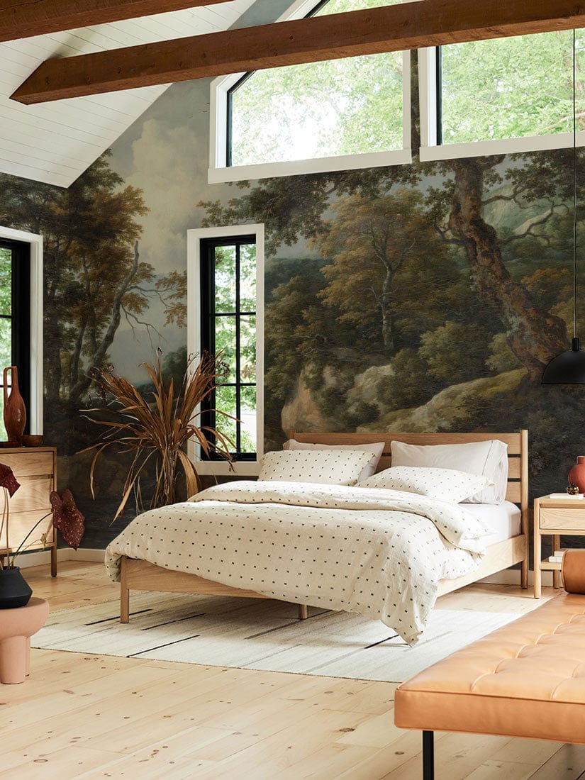 Tranquil forest mural wallpaper, earthy tones, bedroom setting, wooden bed, beige sofa, light wood flooring.