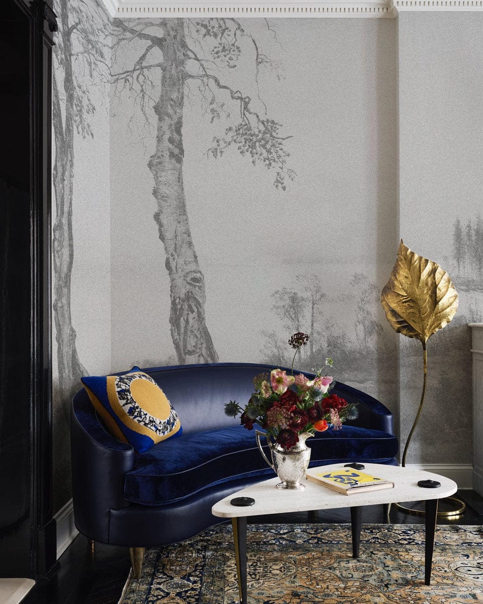 Grey tones landscape mural wallpaper with blue velvet sofa, artistic gold decor in elegant living room.