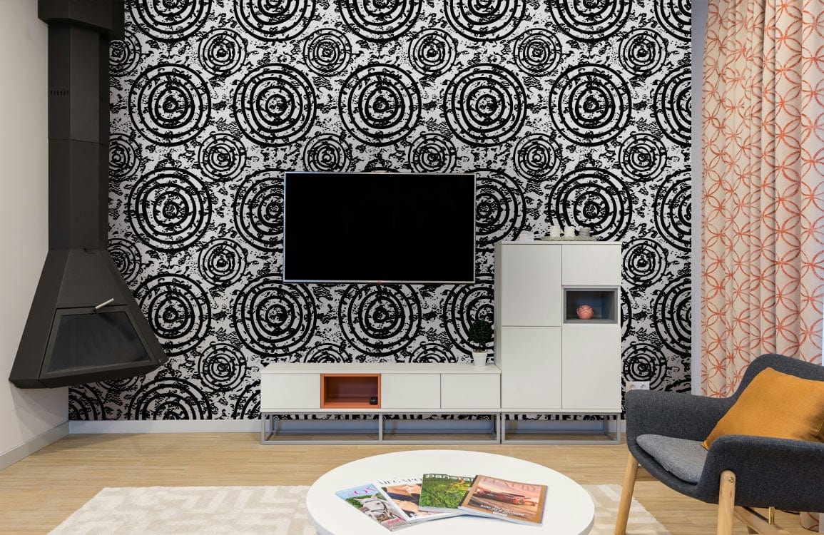 Black and white spiral circles wallpaper, stylish living room with grey chair, modern furnishings, wood flooring.