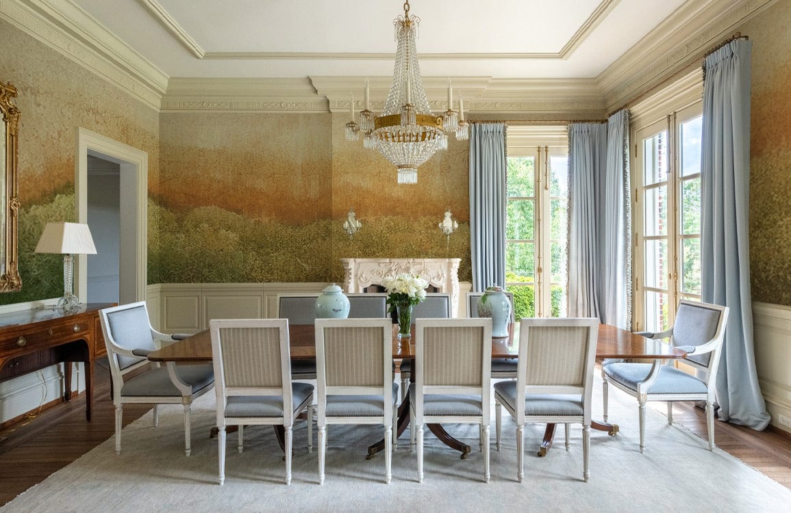 Elegant dining room with Rustic Autumn Forest mural, classic white chairs, wooden table, and chandelier.