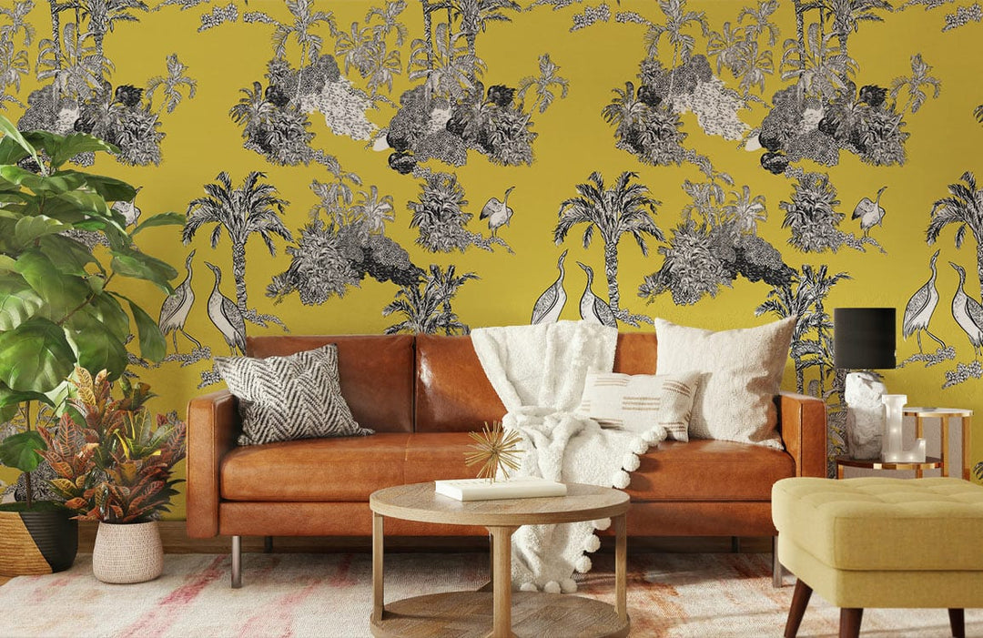 Golden Tropical Oasis Toile Wallpaper in elegant yellow and grey; leather sofa, wooden flooring, cosy room.
