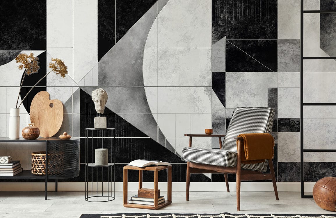 Monochrome geometric Art Deco wallpaper mural in living room with modern chair, ladder, and sideboard.