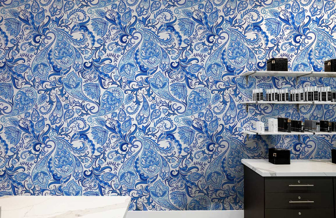 Blue floral paisley wallpaper with elegant vintage design, white shelves, black cabinet, marble countertop.