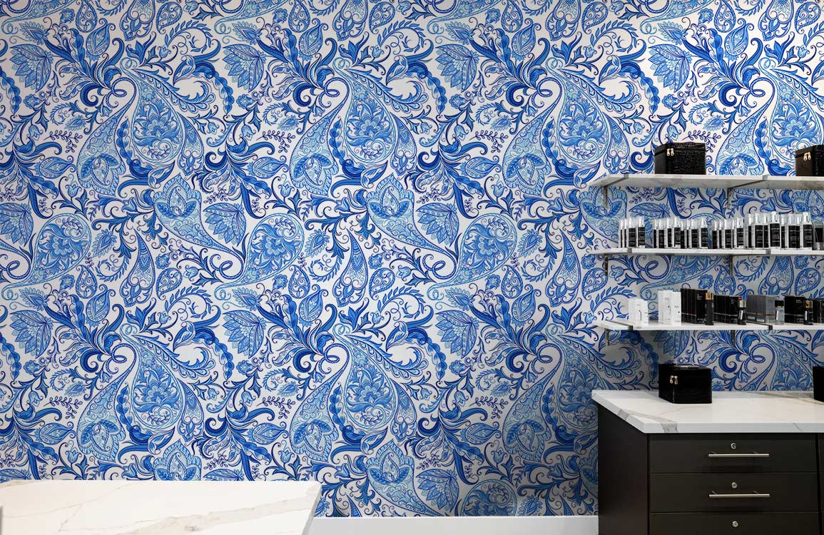 Blue floral paisley wallpaper with elegant vintage design, white shelves, black cabinet, marble countertop.