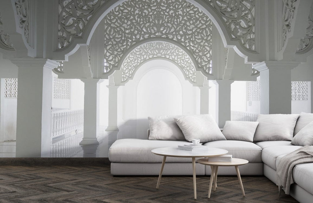 Ornate white archway mural with grey sofa, hardwood flooring, and round coffee table in living room.