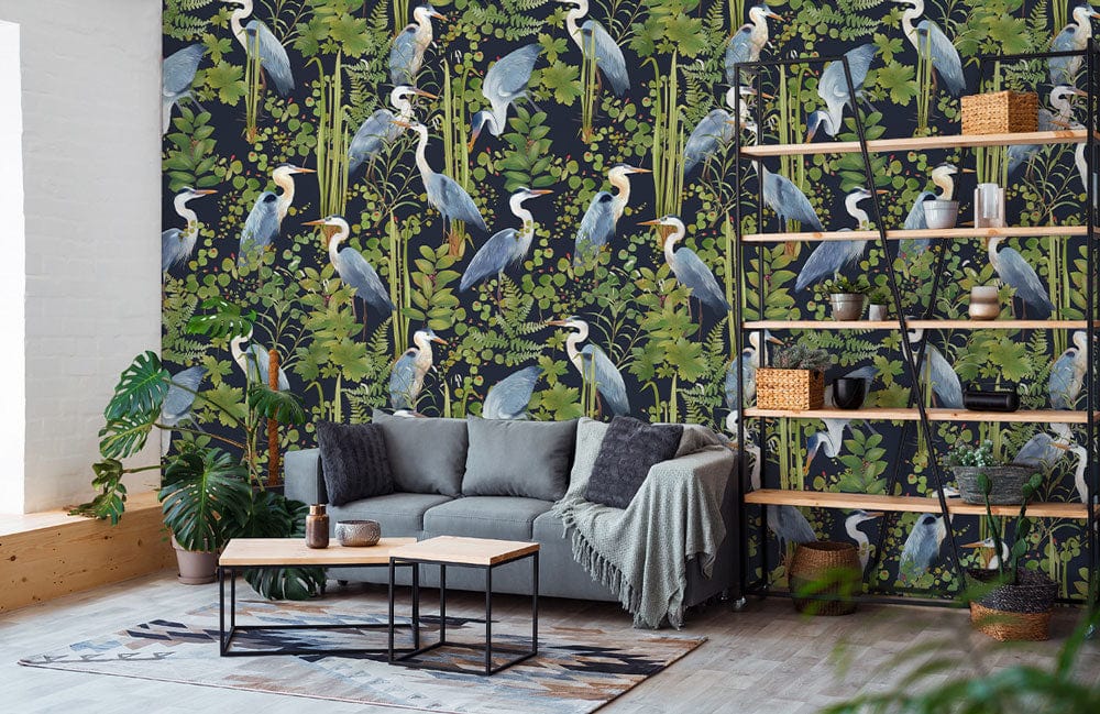 Elegant wallpaper with blue heron pattern, grey sofa, industrial shelving, and hardwood flooring in living room.