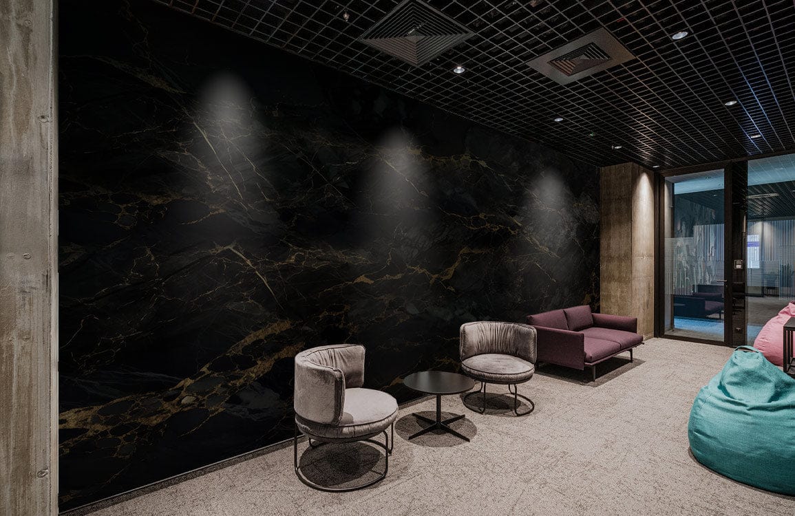 Luxurious black and gold marble wall mural, lounge setting, grey chairs, mauve sofa, carpet flooring.