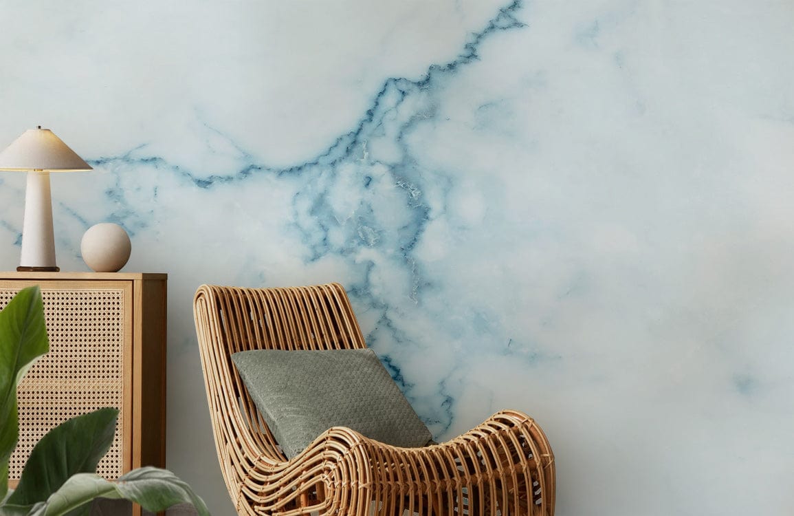 Elegant blue marble effect wallpaper in living room with rattan chair, wooden cabinet, and light decor.
