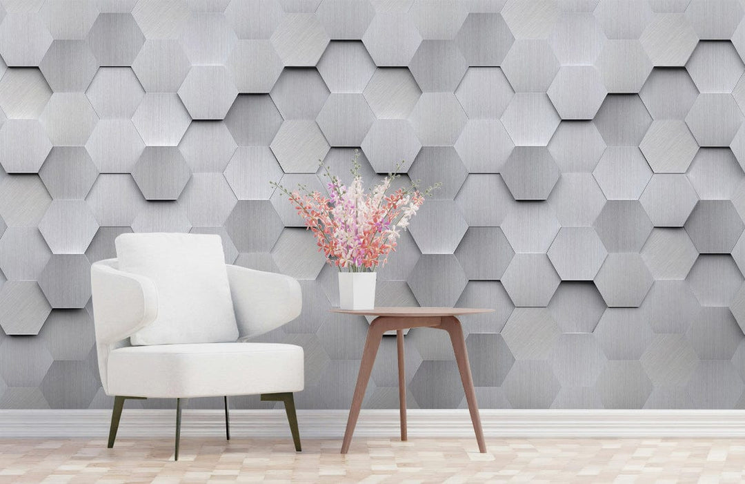 Modern silver hexagonal 3D wallpaper, white armchair, wooden side table, patterned flooring, contemporary room.