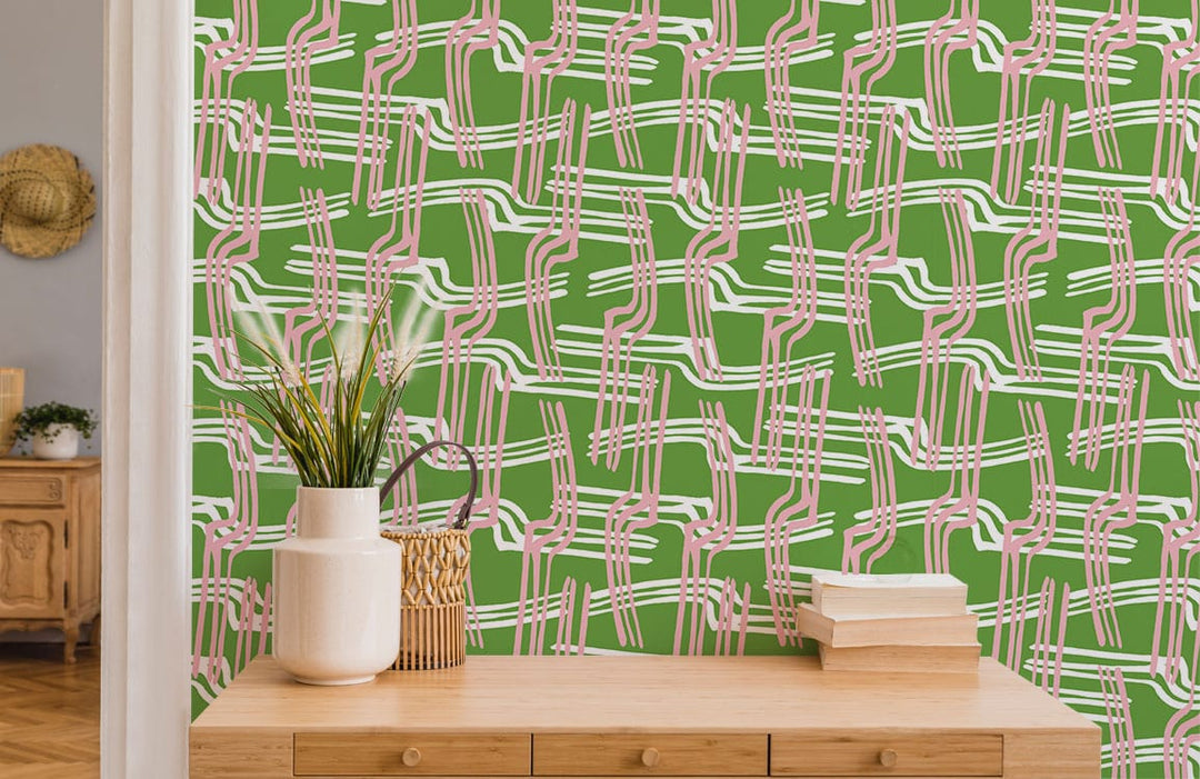Geometric pink and green wallpaper, modern dresser, light wood flooring, cosy interior design.