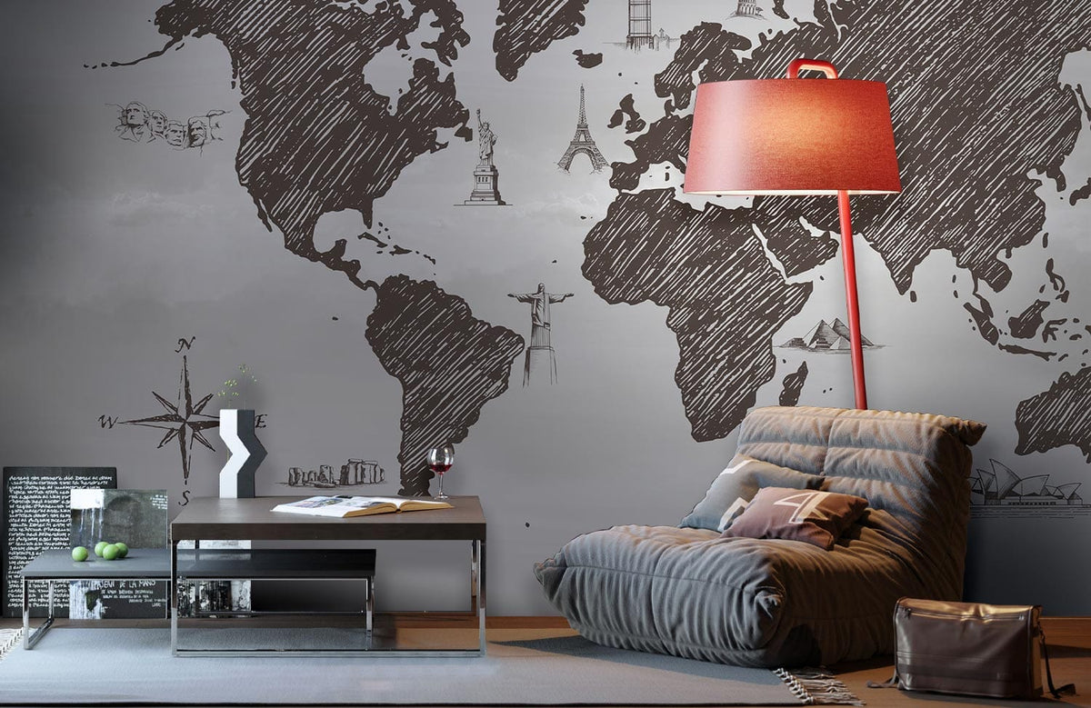 Vintage world map mural wallpaper in charcoal grey, cosy grey armchair, red lamp, modern coffee table.