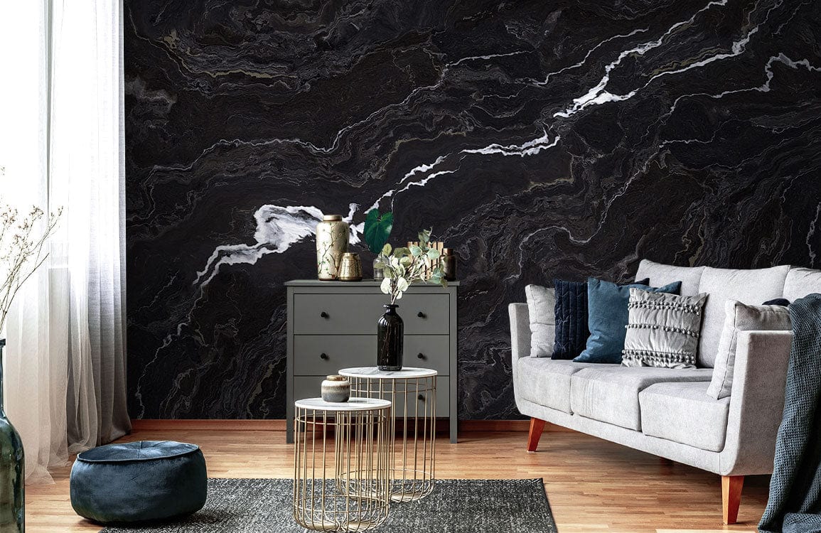 Elegant black marble wallpaper with white veins, grey sofa, modern tables, grey dresser, wooden flooring.