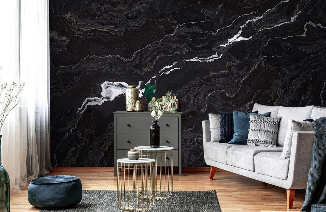Elegant black marble wallpaper with white veins, grey sofa, modern tables, grey dresser, wooden flooring.