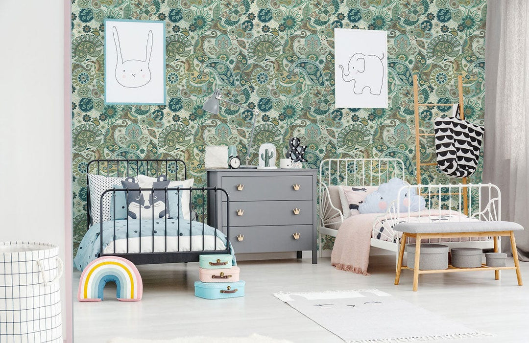 Children's room with teal and beige classic patterned wallpaper, grey dresser, white cribs, light flooring.