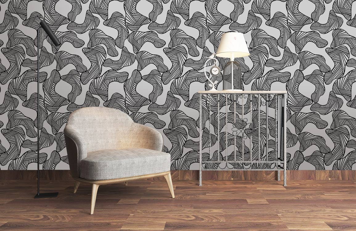 Monochrome abstract line art wallpaper, grey chair, wooden floor, contemporary metal table with lamp.