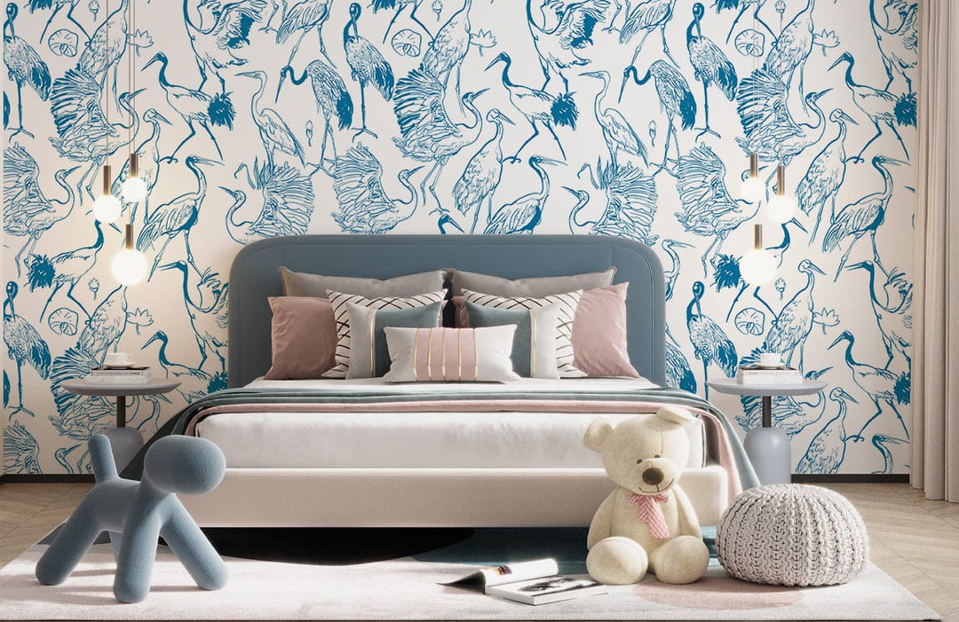 Elegant Blue Heron wallpaper, bedroom with grey bed, modern decor, soft lighting, plush bear, and knit pouf.