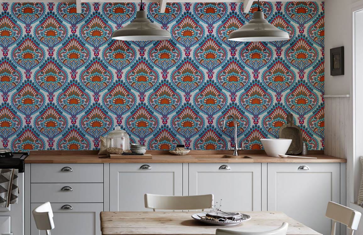 Elegant blue and orange paisley wallpaper in kitchen with white cabinets, pendant lights, and wooden worktops.