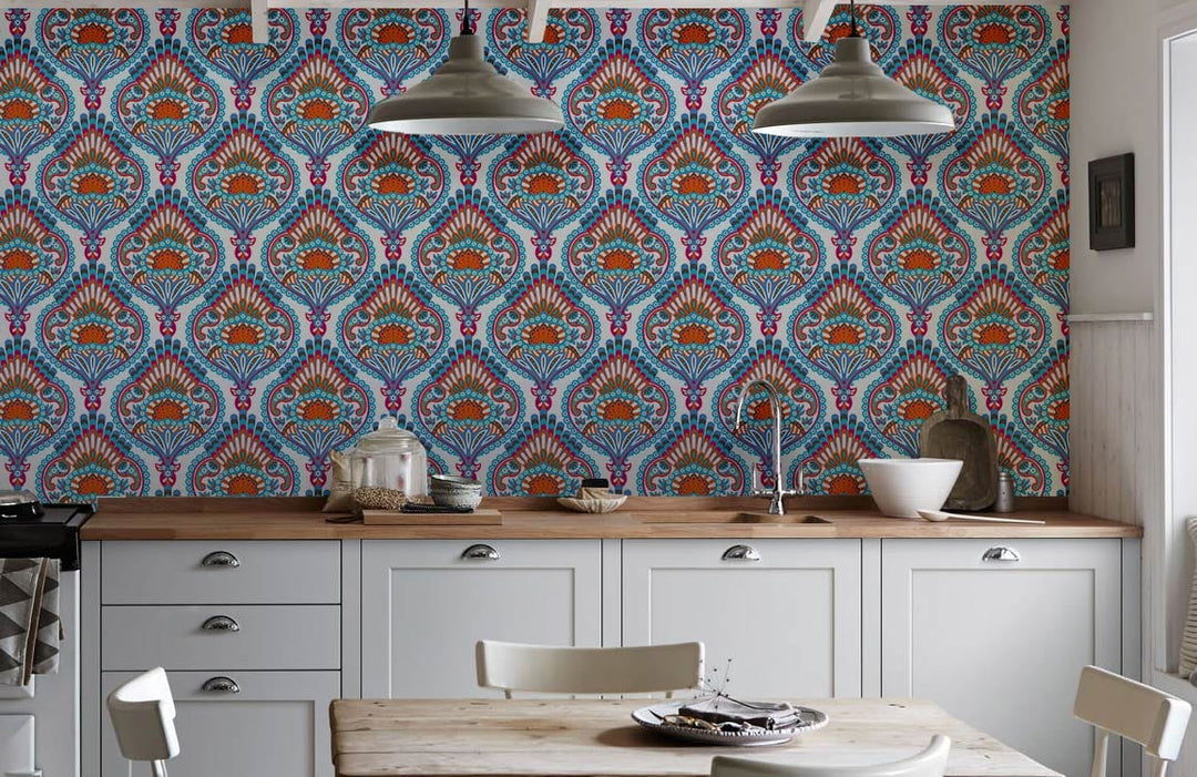 Elegant blue and orange paisley wallpaper in kitchen with white cabinets, pendant lights, and wooden worktops.