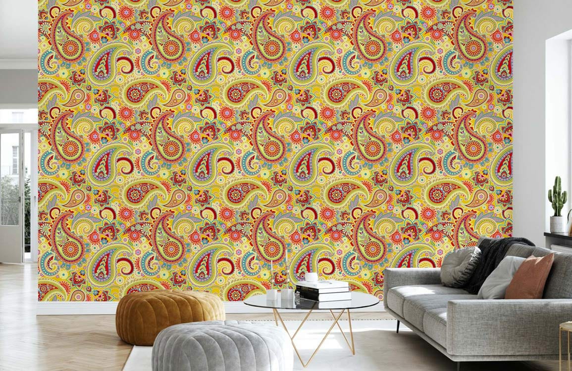 Vibrant paisley wallpaper in a bohemian living room with grey sofa, ottomans, and wooden flooring.