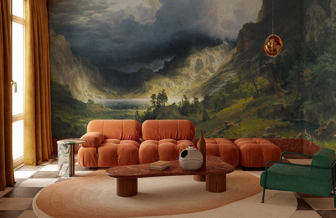 Scenic Mountain Valley Landscape Mural Wallpaper in living room with orange sofa, green armchair, checkered floor.