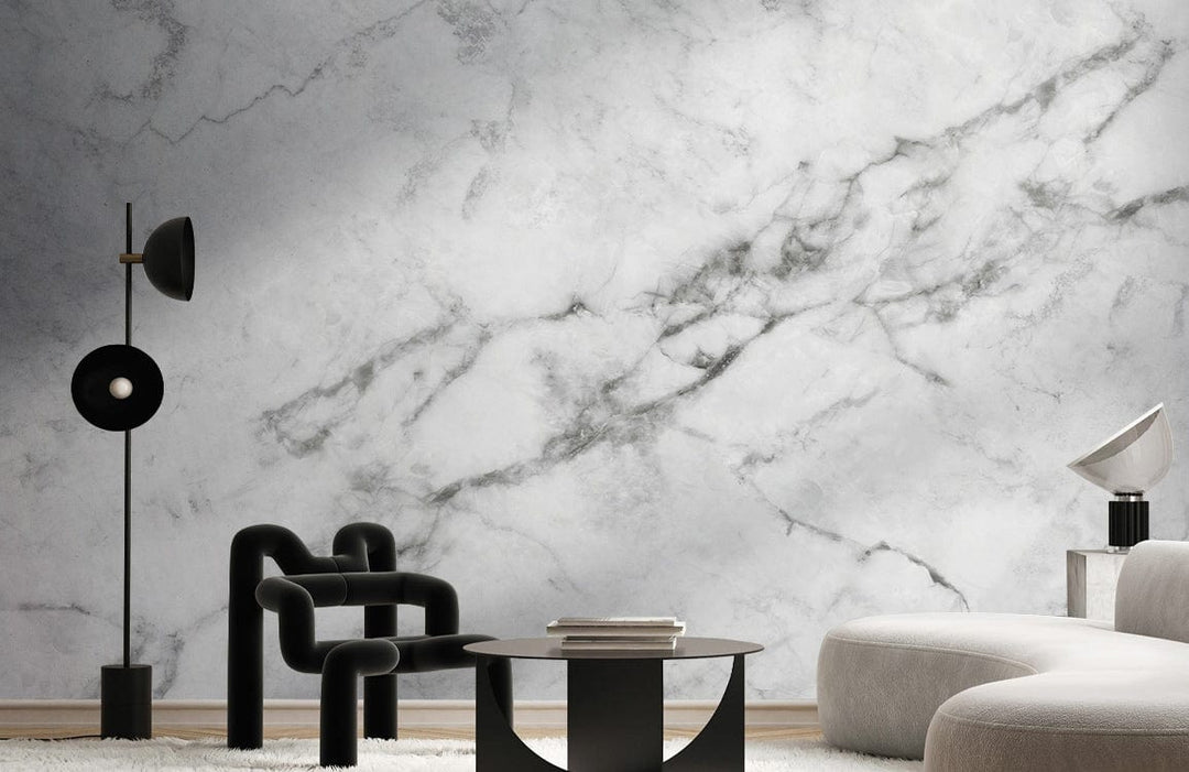 Elegant white marble effect wallpaper in modern living room with black armchair and curved sofa.