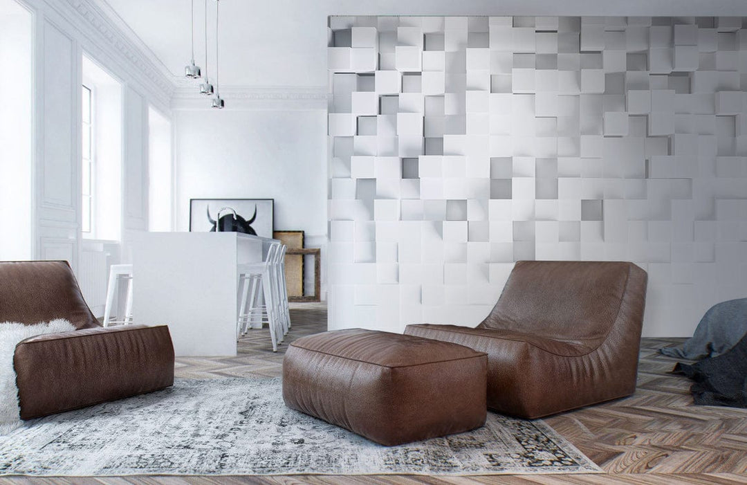 Modern white geometric 3D wall mural, brown leather chairs, herringbone wood floor, and stylish decor.
