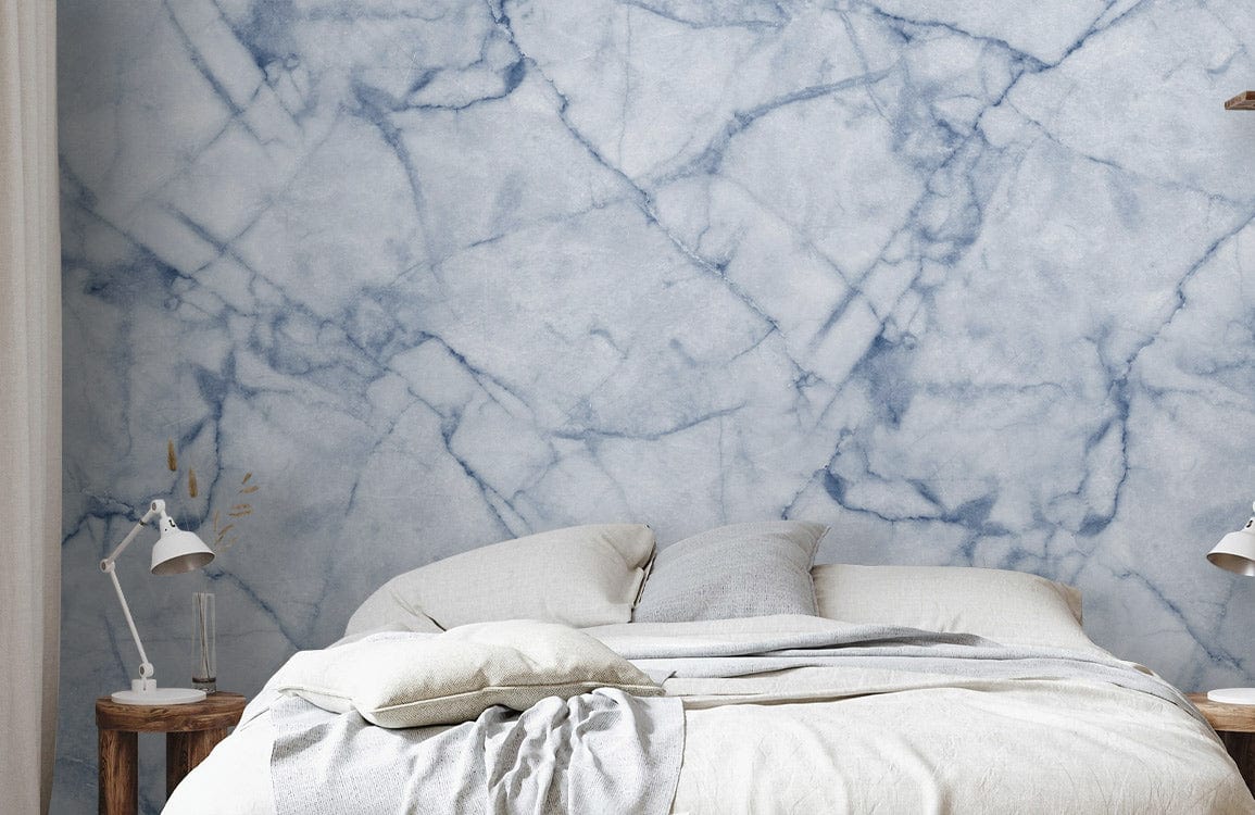 Elegant blue marble effect wallpaper behind neutral bed, matching lamps, and side tables in bedroom.