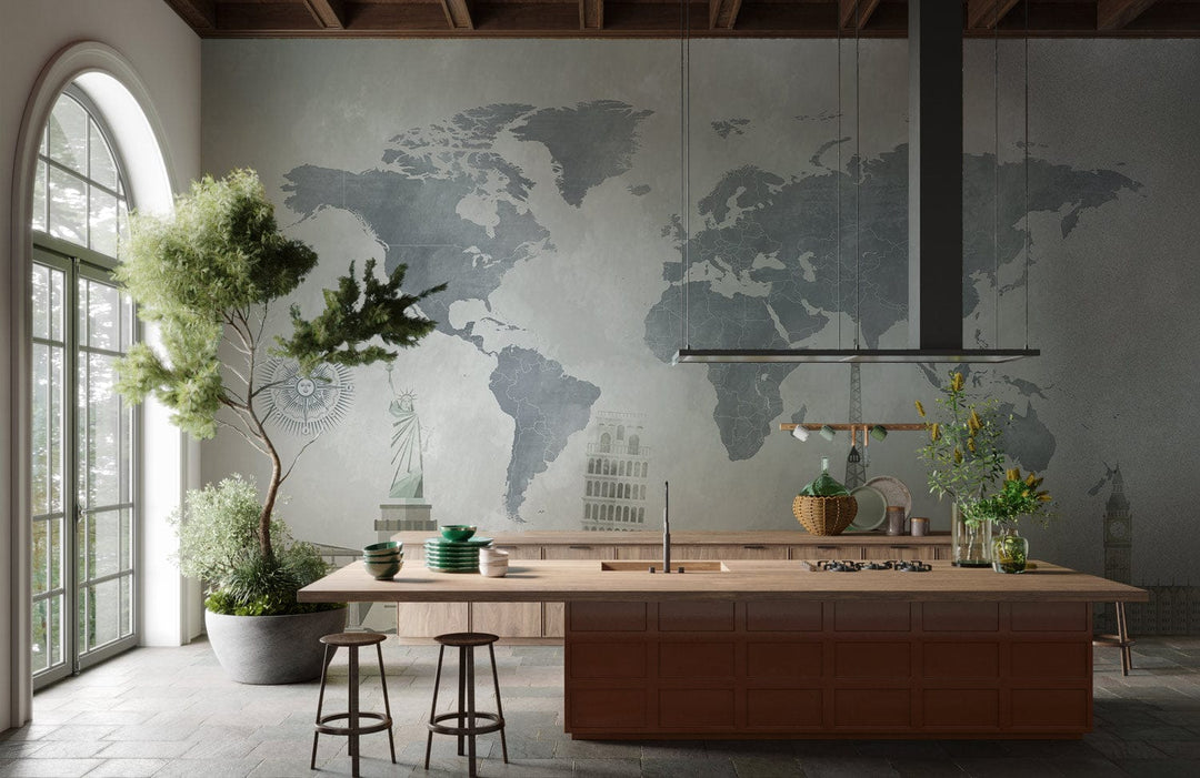 Vintage world map mural wallpaper with iconic landmarks; features modern kitchen, wooden island, stone flooring.