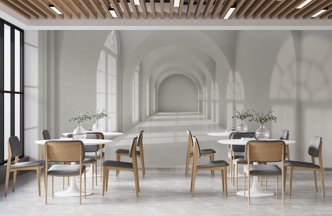 Modern dining area with Elegant White Arched Hallway Mural Wallpaper, wooden chairs, white tables, grey flooring.