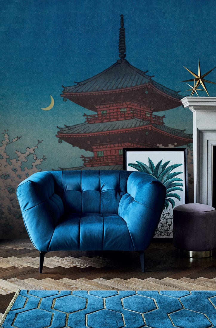 Blue armchair, zigzag wood flooring, mural: Serene Japanese Pagoda, moonlit, cherry blossoms, decorative fireplace.
