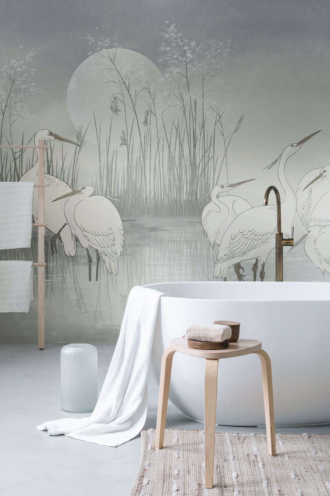 Tranquil Heron Watercolour Mural in bathroom; modern freestanding bathtub; wooden stool; serene setting.