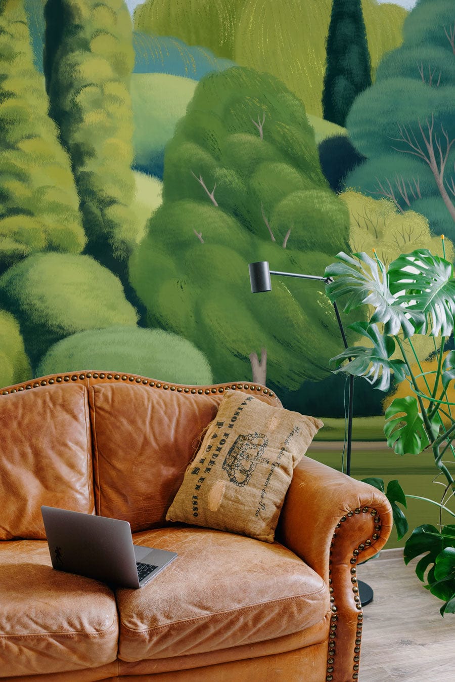 Lush Green Dreamscape Mural with brown leather sofa, wood flooring, modern floor lamp; tranquil ambience.