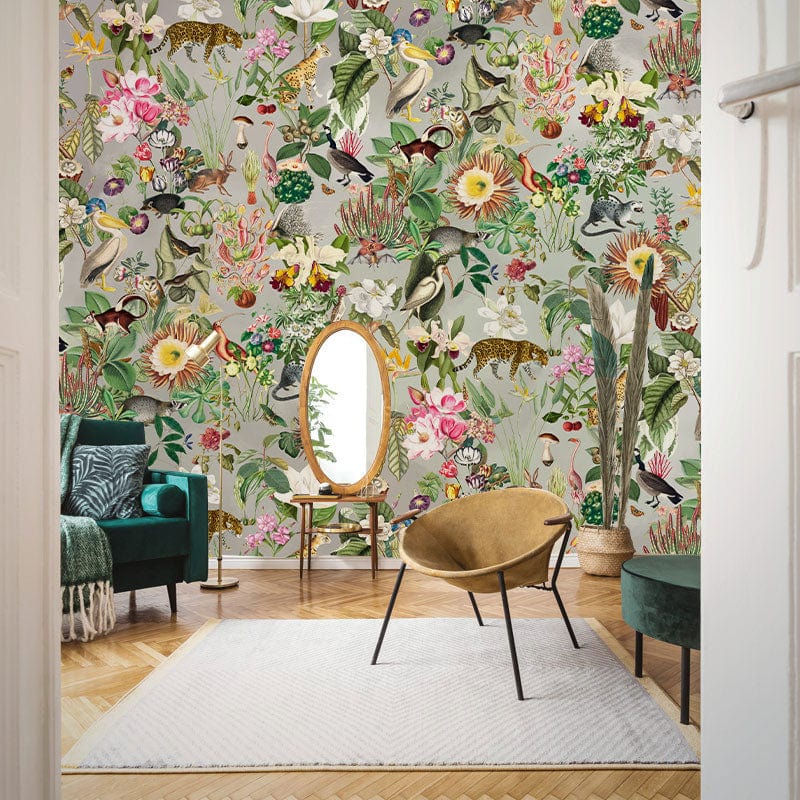 Exotic Jungle Floral Safari Mural Wallpaper in living room; features velvet sofa, wooden flooring, oval mirror.