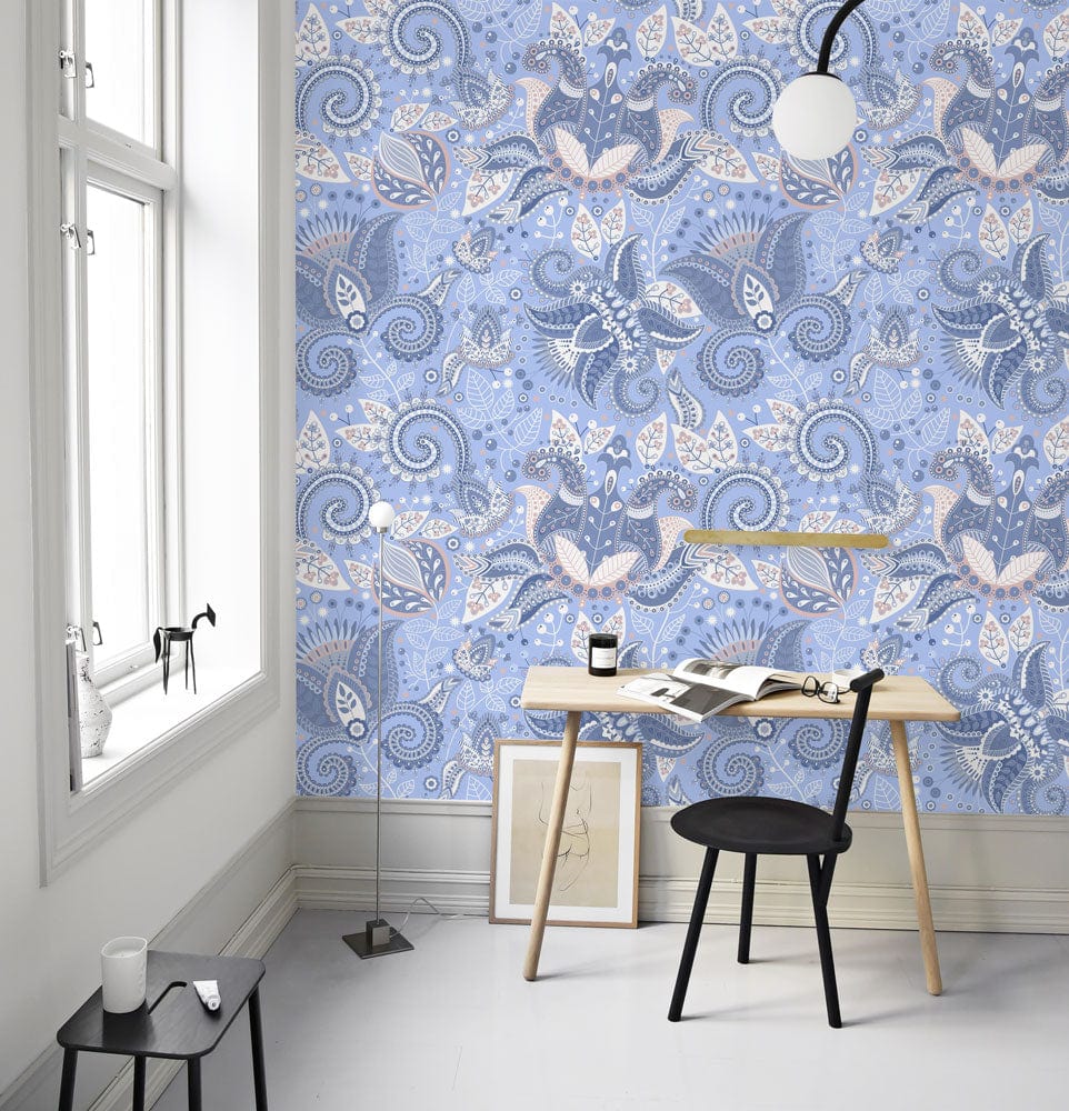 Elegant blue floral paisley wallpaper in modern study with wooden desk, black chair, and white window.