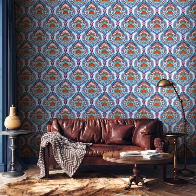 Elegant blue and orange paisley wallpaper in vintage style with brown leather sofa, wooden flooring.