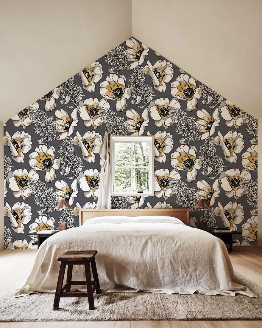 Elegant grey floral wallpaper in bedroom, featuring wooden bed and stool, with light wood flooring.