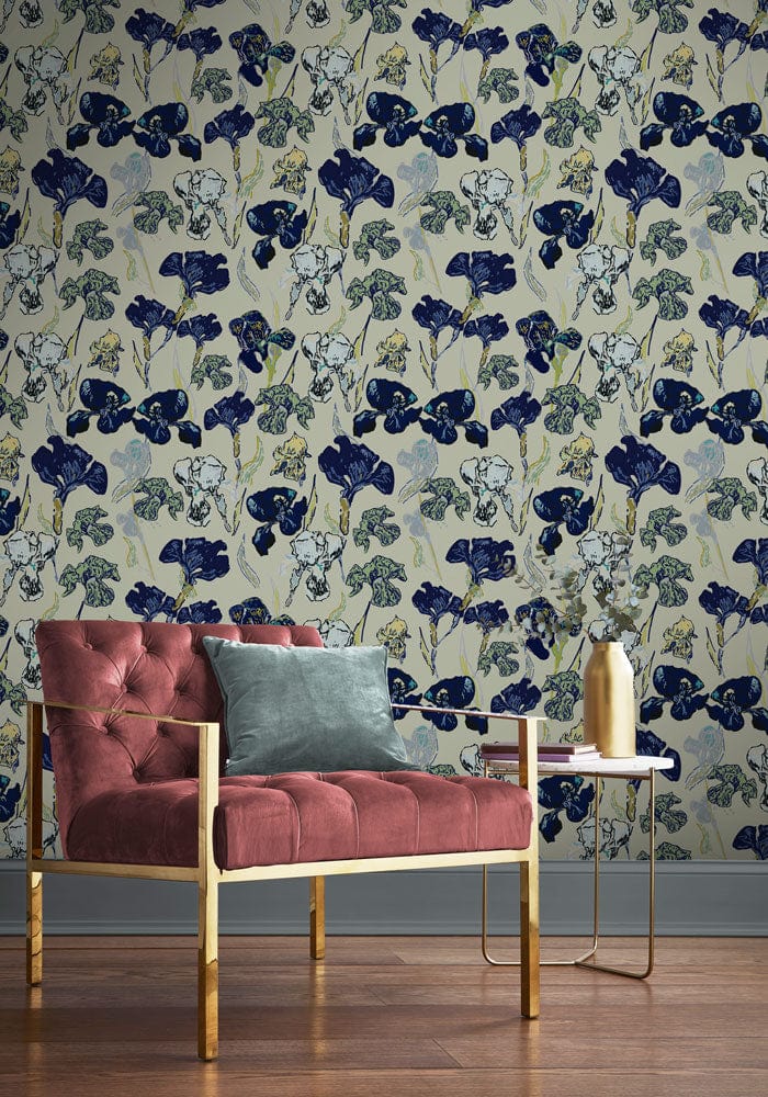 Elegant botanical wallpaper in muted blue and green, featuring velvet armchair and wooden flooring.