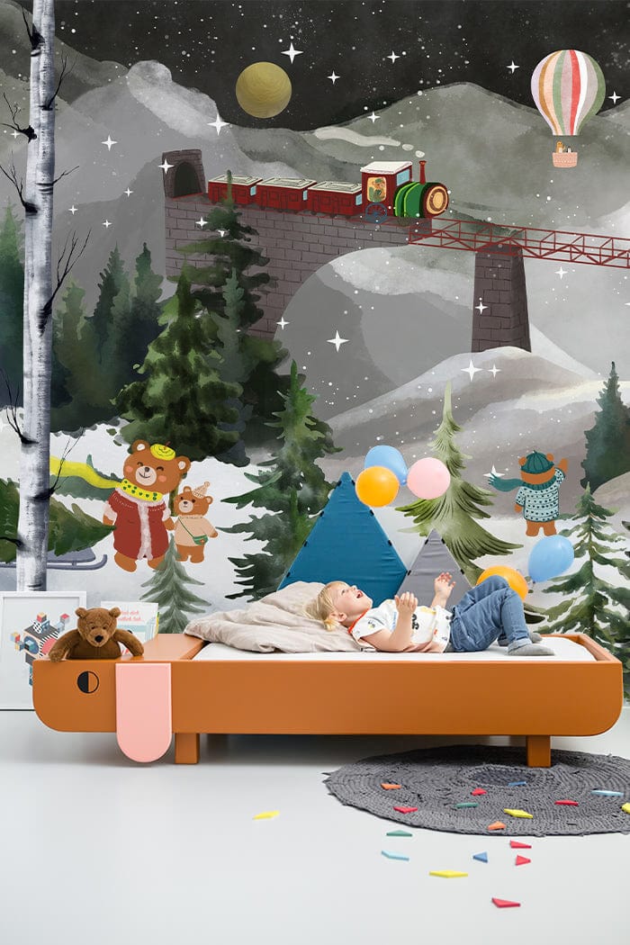 Children's room with Enchanting Winter Wonderland Mural Wallpaper features bears, train scene, wooden bed, playful decor.