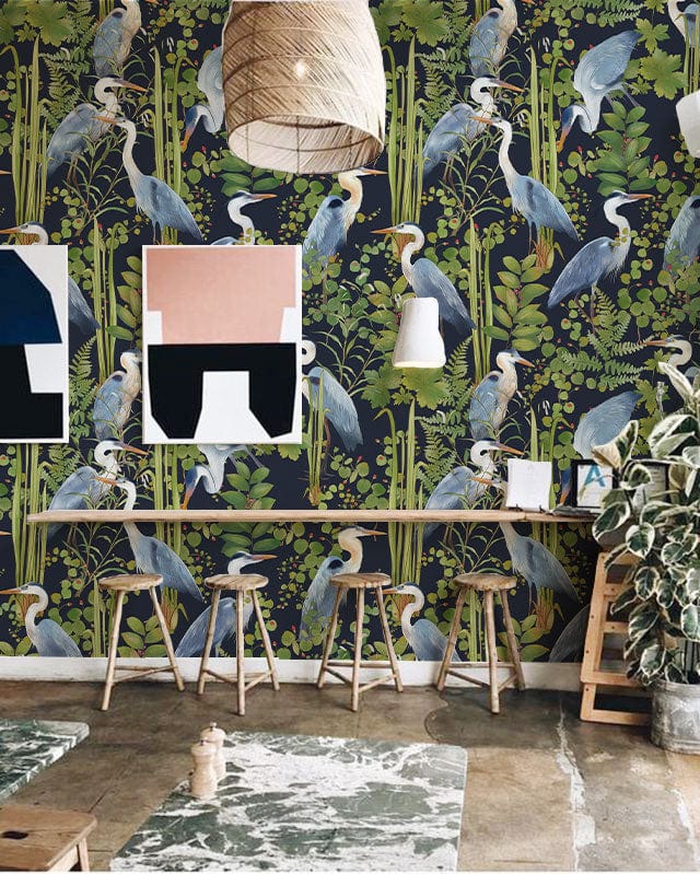 Elegant Blue Heron botanical wallpaper in lush greenery, stools, natural fibre pendant, rustic flooring.
