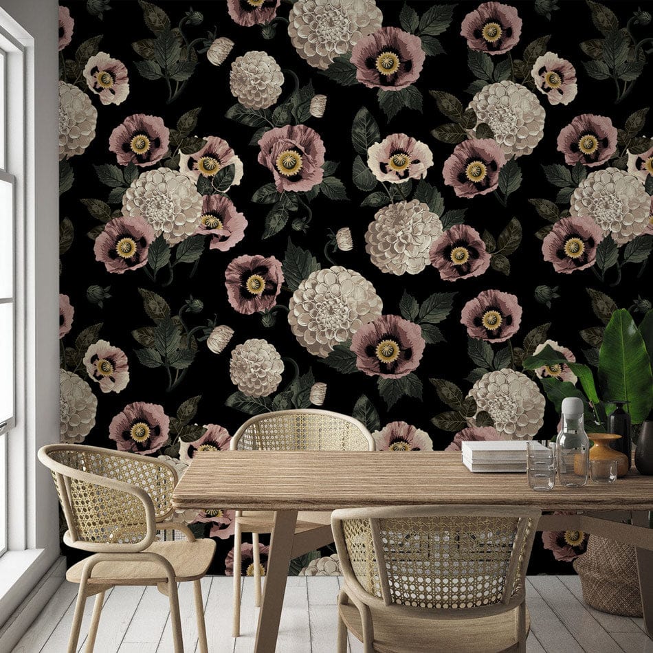 Vintage floral wallpaper featuring pink and cream blooms, wooden table, wicker chairs, black backdrop.