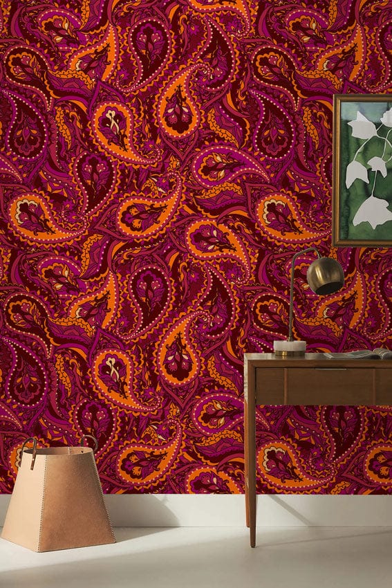 Vibrant paisley wallpaper in rich burgundy tones, mid-century table, modern decor, living room setting.