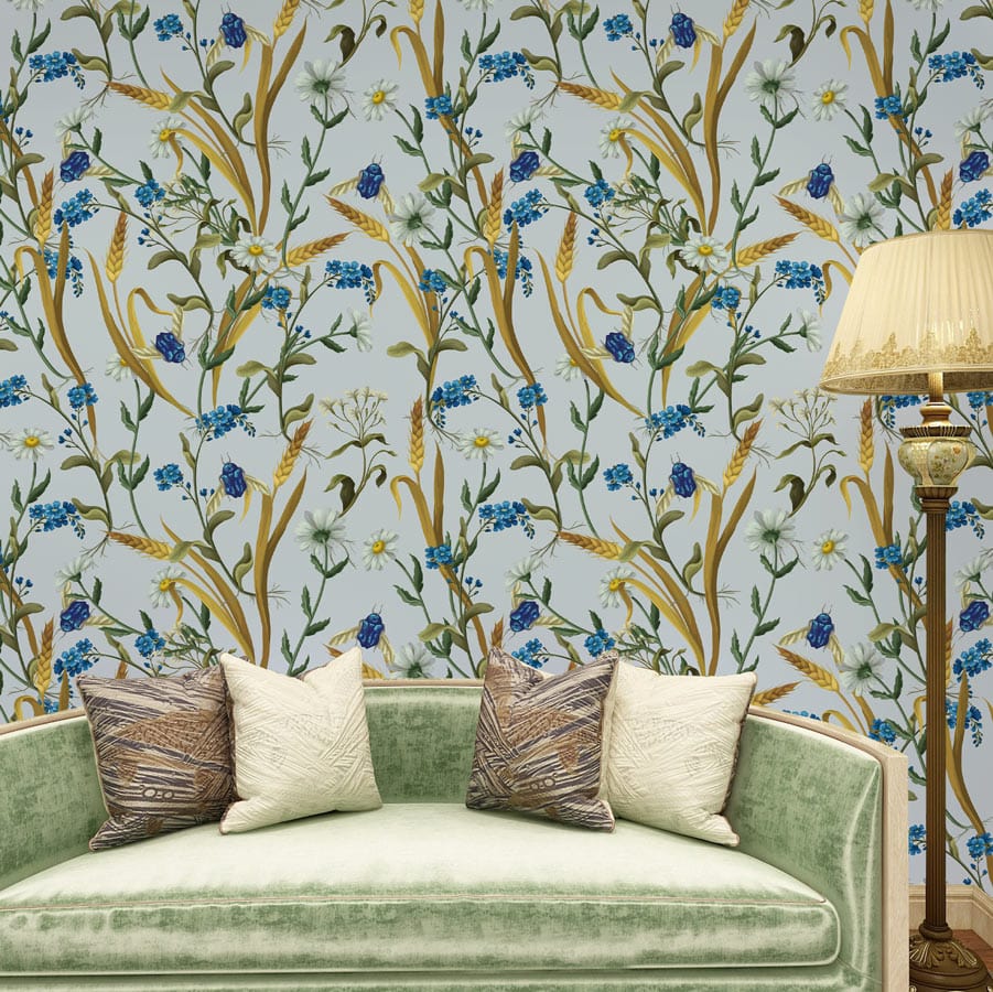 Elegant Blue Floral Meadow Wallpaper complements green velvet sofa and classic lamp in living room setting.