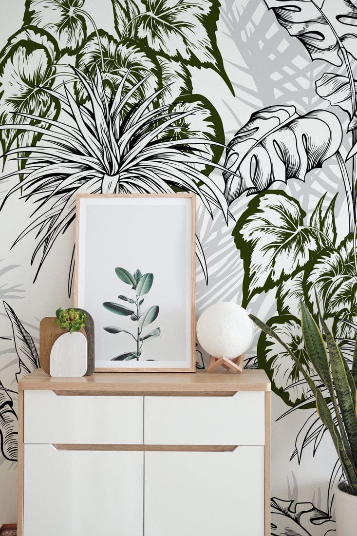 Tropical green botanical jungle wallpaper; monochrome elegance design; white chest; wooden top; vibrant decor.