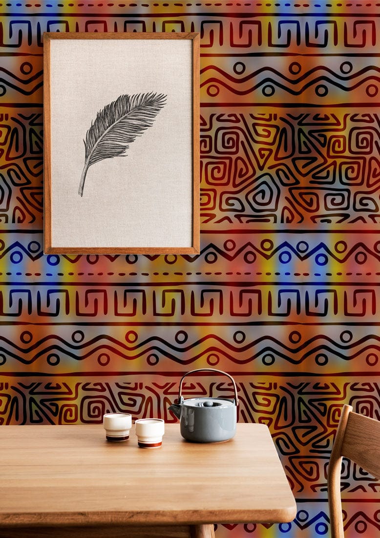 Vibrant tribal geometric wallpaper with orange, blue accents; wooden table, framed feather artwork.