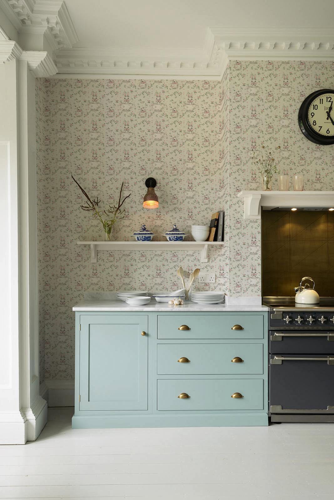 Vintage Pastel Floral Elegance: Neutral wallpaper in kitchen with light blue cabinets, floral wallpaper, stove.