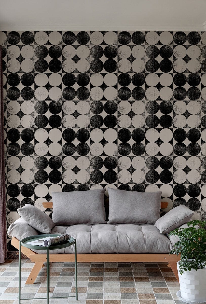 Monochrome geometric op art circles pattern wallpaper with grey sofa and mosaic tiled flooring in living room.