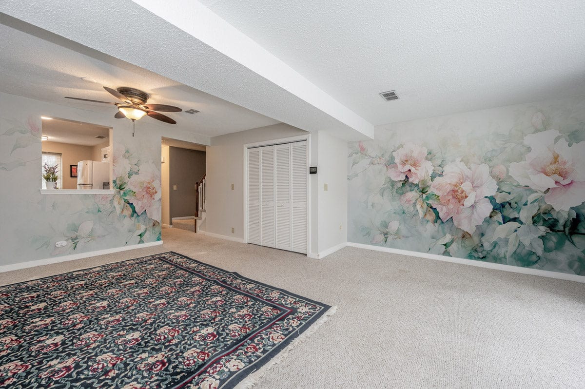 Living room with Elegant Pastel Floral Watercolour Mural Wallpaper, floral pattern rug, and neutral carpeting.