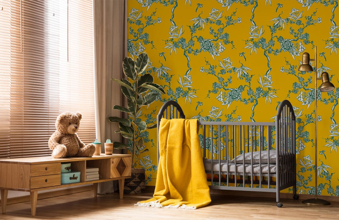 Vintage botanical mustard floral wallpaper with green accents in nursery, featuring grey crib, wooden flooring.