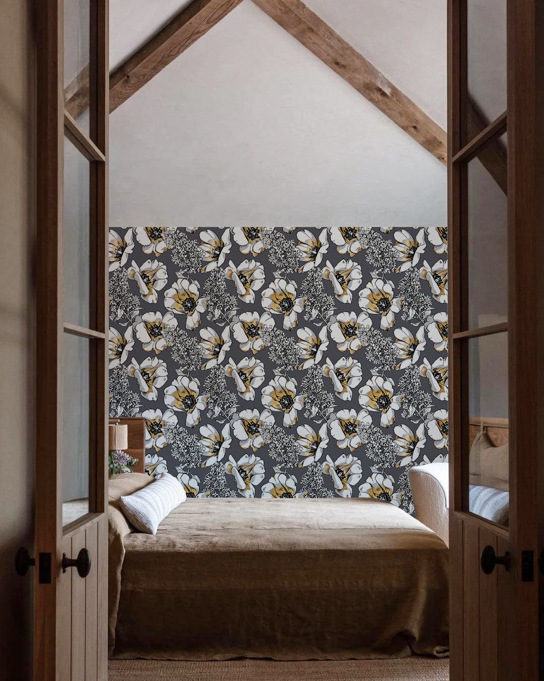 Elegant grey floral wallpaper in bedroom with wooden beams, cosy beige sofa, and rustic design.